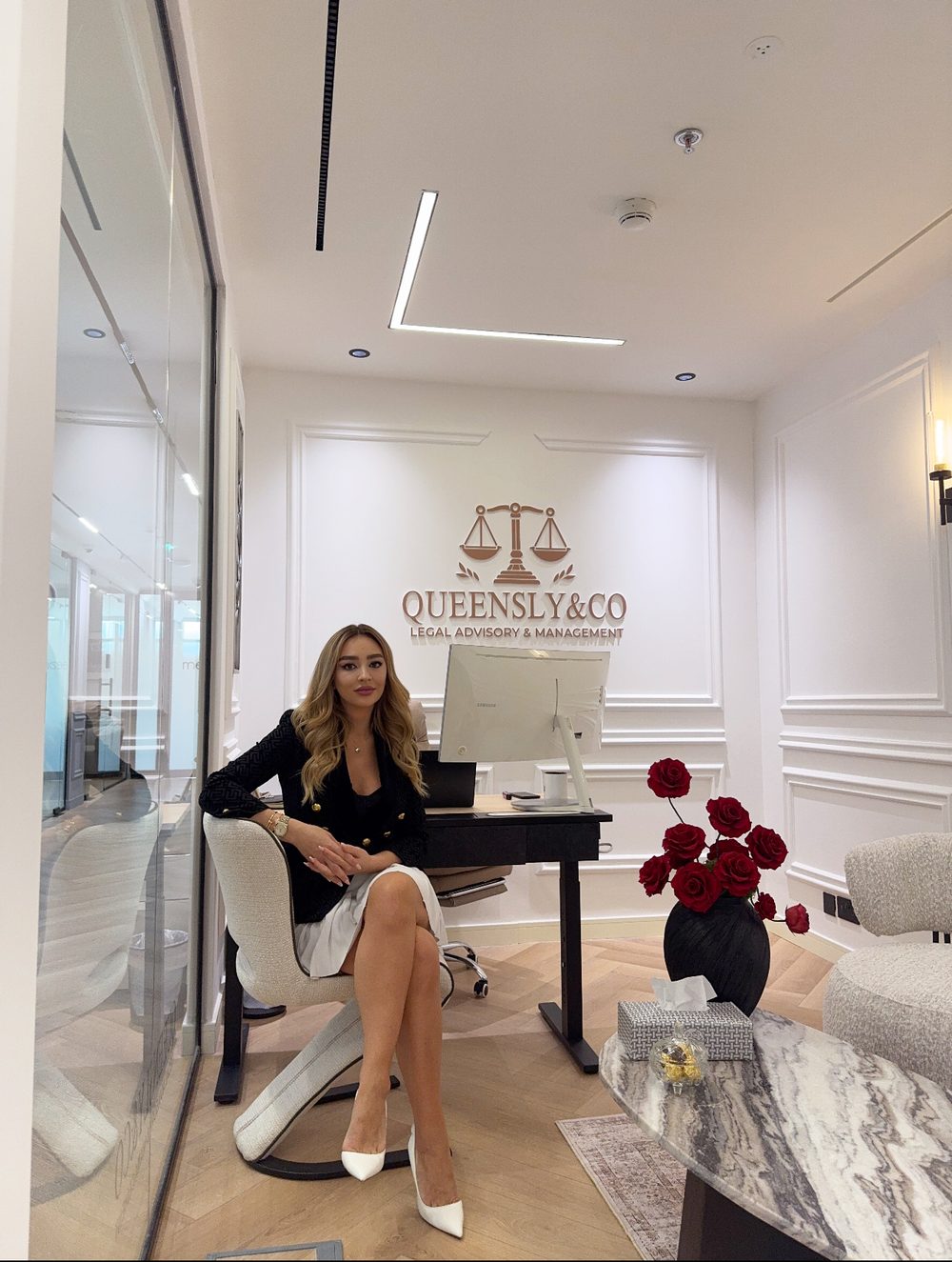 Raluca Radoi, Managing Director, seated in the Queensly & Co office
